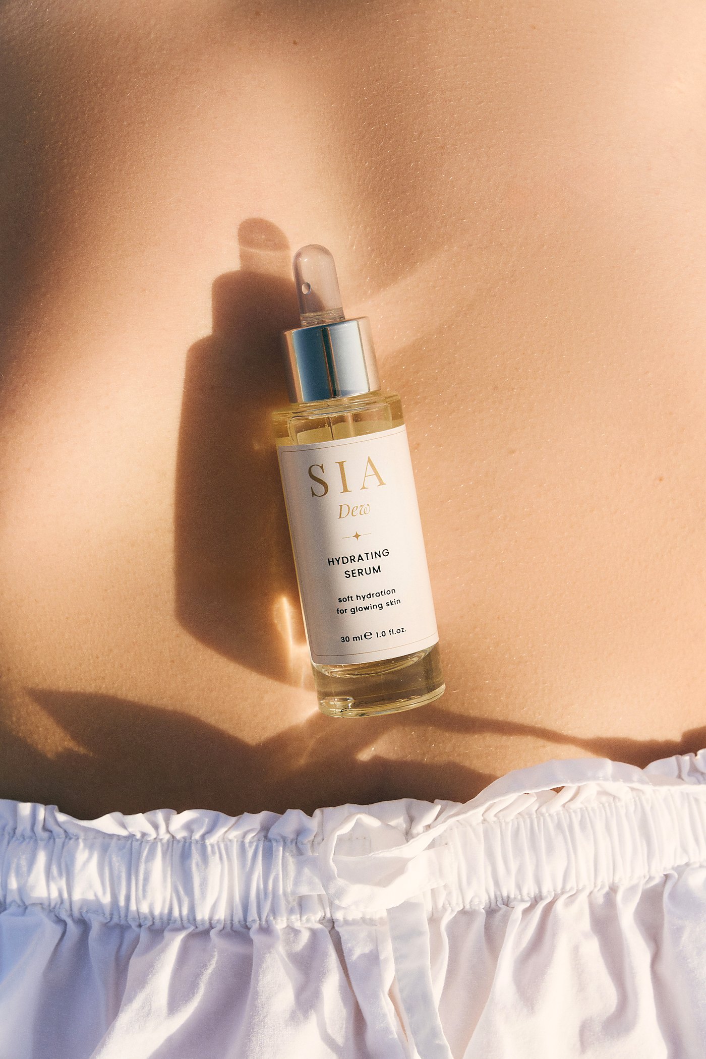 SIA DEW Hydrating Serum bottle in warm sunlight